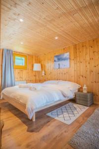 a bedroom with a large bed in a wooden wall at Chalet avec vue in Nendaz
