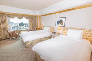a hotel room with two beds and a window at Lotte Hotel Busan in Busan