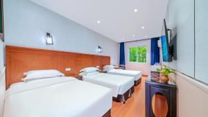 a row of beds in a room with a tv at Wenjun Courtyard Hotel ---5 mins walk from Tonghuimen metro station, near Tianfu square, close by culture park and Sichuan opera house, English speaking service, local tours in Chengdu