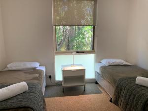 a room with two twin beds and a window at The Hastings Beach Houses in Noosa Heads +78 photos