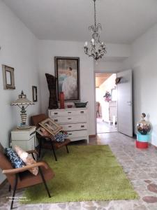 un soggiorno con una cassettiera e un tappeto verde di Good Art a Strevi