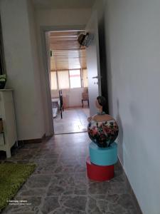 una stanza con un vaso appoggiato su uno sgabello rosso e blu di Good Art a Strevi