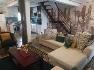 a living room with two couches and a staircase at Résidence La Tonnelle in Antananarivo