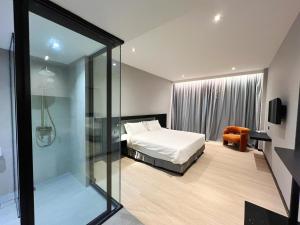 a bedroom with a bed and a glass wall at Crystal Crown Hotel Kuala Lumpur in Kuala Lumpur