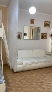 a white couch in a living room with a staircase at Dori 's place in Vlorë