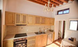 a kitchen with wooden cabinets and a sink at Unique Stes Lindos in Lindos
