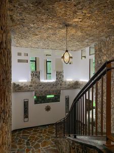 a staircase in a stone building with a chandelier at AG Casa O Remanso de Pedreira con finca 20000 m in Carballo