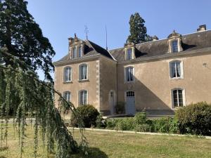 a large brick building with a tree in front of it at Le petit gîte du theil au servant in La Chapelle-Viviers