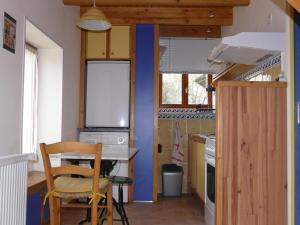 a kitchen with a table and a chair in a room at Les boulites in Roches-Prémarie-Andillé