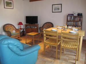 a living room with a table and chairs and a television at Les boulites in Roches-Prémarie-Andillé