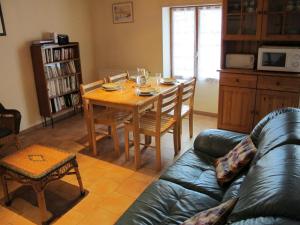 a living room with a table and a leather couch at Les boulites in Roches-Prémarie-Andillé +4 photos