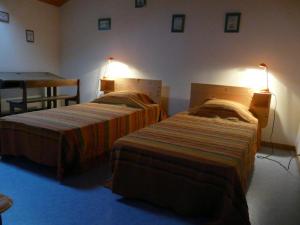 two beds in a hotel room with two lamps at Les boulites in Roches-Prémarie-Andillé