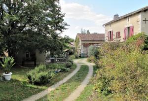 a dirt road through a yard with houses at Les boulites in Roches-Prémarie-Andillé