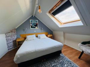 a bedroom with a large bed in a attic at Balsemientexel in De Koog