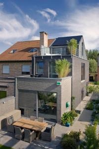 a house with a wooden table in front of it at Aan Den Oever Logies in Korbeek-Dijle
