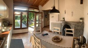 a kitchen with a table and a fireplace in a room at Il Granaio - Historic Molino Maufet Watermill - Lake Como in Colico