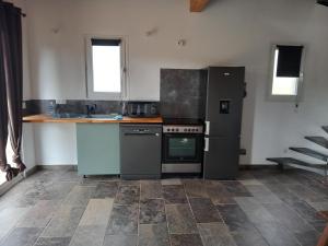a kitchen with a stove and a refrigerator at maison de vacances olmi cappella Corse in Olmi-Cappella
