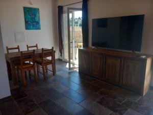 a living room with a large flat screen tv and a dining table at maison de vacances olmi cappella Corse in Olmi-Cappella