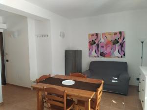 a living room with a table and a couch at Casavacanze corallo in Isola delle Femmine