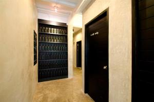 a hallway with black doors and racks of wine bottles at DI Place in Bangkok +18 photos