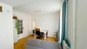 ein Wohnzimmer mit Sofa und Tisch in der Unterkunft Chambre privée proche Accord Arena et avec metro 20 min de la Tour Eiffel in Paris