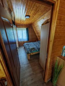 a small room with a bed in a wooden house at A Frame Alpin in Vatra Dornei
