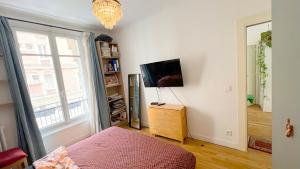 ein Schlafzimmer mit einem Bett und einem Flachbildfernseher in der Unterkunft Chambre privée proche Accord Arena et avec metro 20 min de la Tour Eiffel in Paris