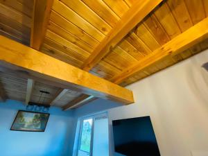 a living room with a wooden ceiling and a tv at Dom Wakacyjny Bogaczewo in Bogaczewo
