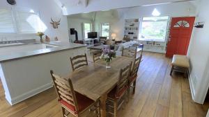 a kitchen and living room with a wooden table and chairs at Intown Contemporary Prime Street, Fenced Yard, Bright And Open Concept Design in Bozeman