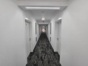 an empty hallway with white walls and a long corridor at Ilinca in Neptun