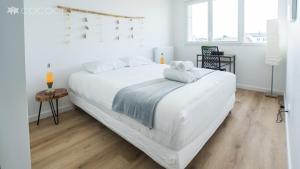 - un grand lit blanc dans une chambre blanche dotée de parquet dans l'établissement VANNES ROOF TOP 2 a 4 a 6 a 8 pers 120 m plein sud EXCEPTIONNEL, à Vannes
