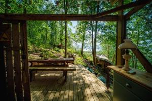 a screened in porch with a picnic table and a bench at Gränna Glamping in Gränna