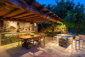 an outdoor patio with a wooden table and chairs at Sifnos Roots in Exámbela