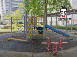 Un parque infantil con un tobogán y dos sillas y un cartel. en Staycation Homestay 54 Skyvilla Condo near MJC, en Kuching