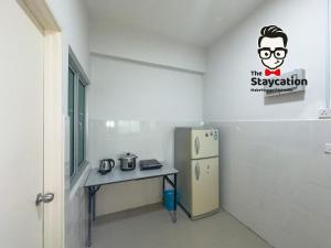 Una pequeña cocina con una mesa y un refrigerador. en Staycation Homestay 54 Skyvilla Condo near MJC, en Kuching