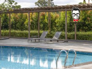 2 tumbonas junto a la piscina en Staycation Homestay 54 Skyvilla Condo near MJC, en Kuching