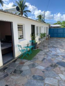 a house with a patio with a table and chairs at Studio Les Coraux in La Saline les Bains