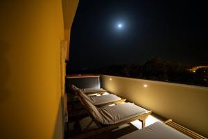 a row of lounge chairs on a balcony at night at Residenza Capriccioli in Porto Cervo