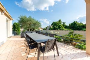 a table and chairs on the patio of a house at La Maison Paradis - Piscine privée et chauffée in Luçon