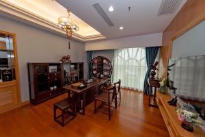 a living room with a wooden table and chairs at Gladden Hotel Jiangmen in Jiangmen