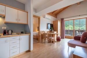 a kitchen with a living room and a bedroom at Hotel Residence MaVie in Lagundo