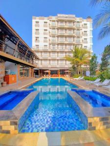 a hotel with a swimming pool in front of a building at Mandalay Lodge Hotel in Mandalay