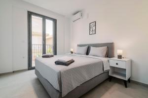 une chambre blanche avec un grand lit et une fenêtre dans l'établissement Koskinou Escape Villa, à Koskinou 31 autres photos