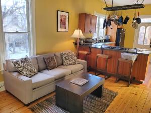 a living room with a couch and a kitchen at Just Two Blocks From Downtown Bozeman, The Dahlia House Is A Tucked Away Retreat in Bozeman