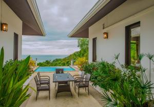 a patio with a table and chairs and a pool at Luxurious Pool villa with great sea view in Koh Phangan