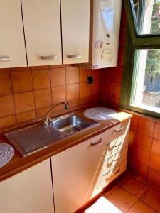 een kleine keuken met een wastafel en een raam bij Residence Leonardo sul mare in Silvi Marina
