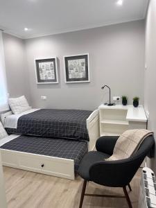 een slaapkamer met een bed en een stoel bij CASA NIEVES Centro Moaña in Moaña
