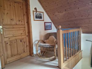 a room with a rocking chair and a staircase at Ferienwohnung Lootsenhuus 85115 in Ostrhauderfehn