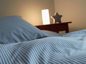 ein Bett mit blauer Decke in einem Schlafzimmer in der Unterkunft Gästezimmer Haus Tulpenstraße in Elsfleth