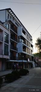a large apartment building with people walking in front of it at CENTAR CEPERKOVIC in Vrnjačka Banja